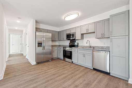 A kitchen with wooden floors and stainless steel appliances.