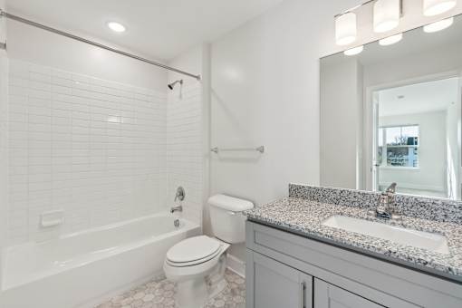 A white bathroom with a sink, toilet, and bathtub.