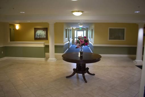 A vast hallway with a display table and colorful flowers