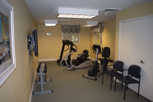 A fitness room fully equipped with a treadmill, exercise bike, and a television.