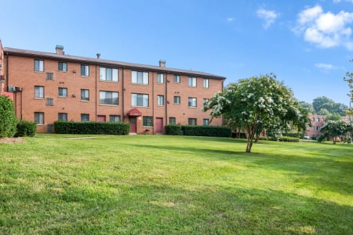 Exterior view of Meadowbrook Run Apartments, an Enterprise community in Congress Heights, Washington, D.C., surrounded by mature trees and green space, showcasing a peaceful park-like setting