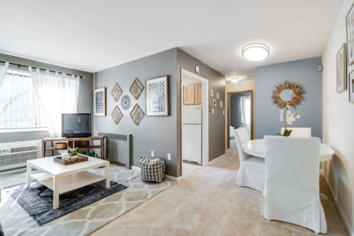 Spacious living room inside a Meadowbrook Run apartment home featuring large windows with natural light, hardwood-style flooring, and a neutral color palette for flexible furnishing options.