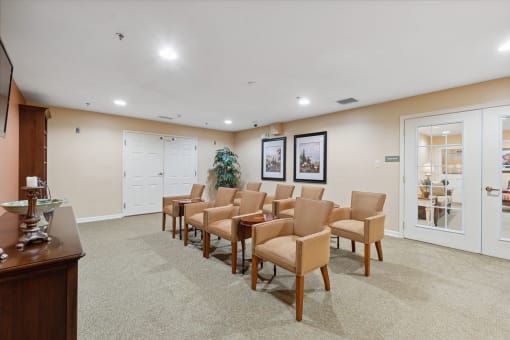 a room with a row of chairs in front of a tv