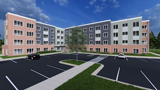 A parking lot in front of a multi-story building.
