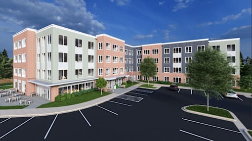 A large multi-story building with a parking lot in front.