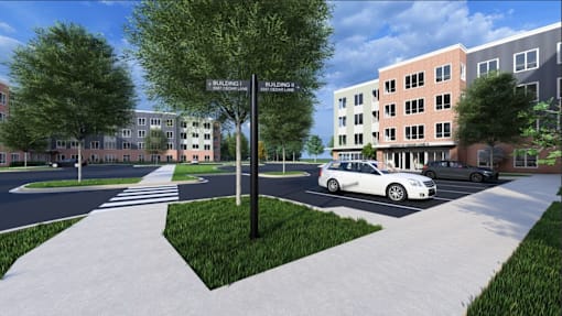 A street view of a residential area with a crosswalk and a car parked on the side of the road.