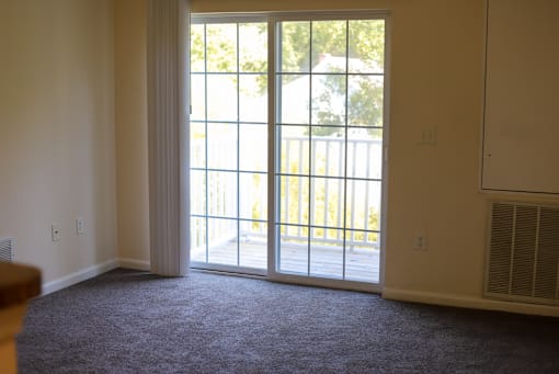 A room with a sliding glass door leading to a backyard.