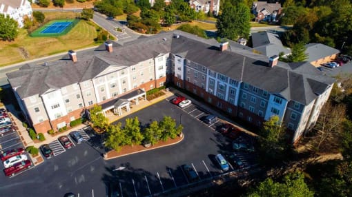 Exterior view of Park View at South Pantops, a senior apartment community in the Carriage Hill area near Charlottesville, featuring well-maintained buildings, landscaped grounds, and convenient on-site parking for adults age 62 and better.