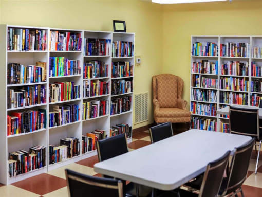 Well-stocked resident lending library at Park View at South Pantops, offering books, comfortable seating, and a quiet space for relaxation and lifelong learning in this 62+ senior community.