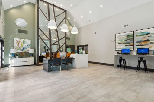a lobby with a reception desk and a desk with a computer on it at The Hartley at Sweetwater Creek, Duluth, GA, 30096