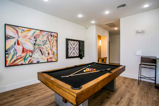 Octave Apartments  a game room with a pool table and a painting on the wall