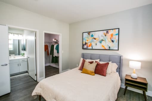 Octave Apartments a bedroom with a bed and a nightstand with a lamp