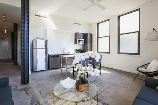 A modern kitchen with a glass table and a refrigerator.