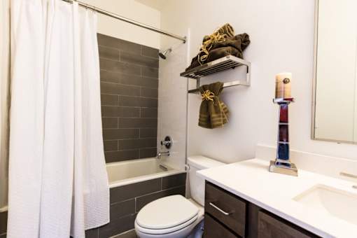A bathroom with a white toilet, a white shower curtain, and a white sink.