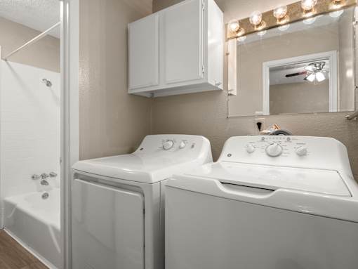 A white washing machine and dryer in a laundry room.