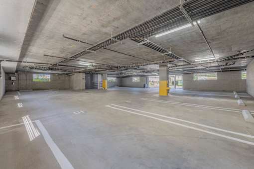 A large, empty parking garage with concrete floors and walls.