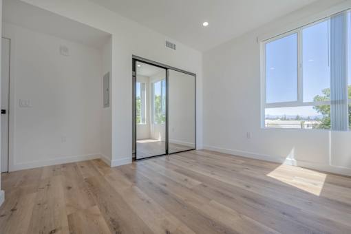 A room with a sliding glass door leading to a balcony.