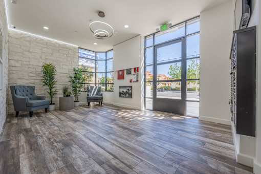 A room with a grey sofa and a wooden floor.