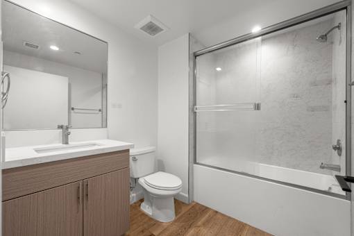 A bathroom with a toilet, sink, and shower.