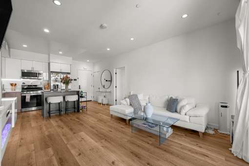 A modern living room with a white sofa and wooden flooring.