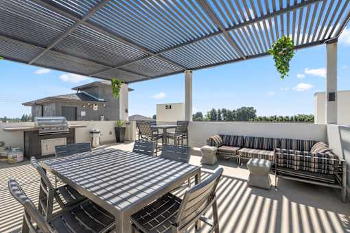 A patio with a table and chairs under a roof.