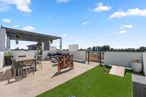 A patio with a table and chairs under a pergola.