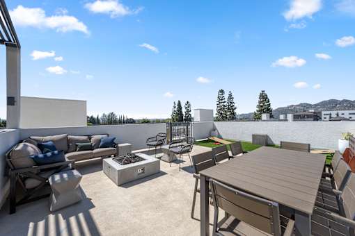 A patio with a table and chairs is set up on a sunny day.