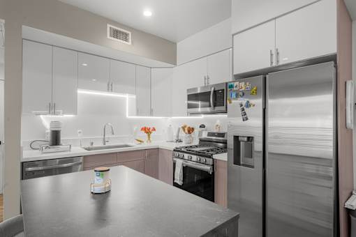 A modern kitchen with stainless steel appliances and a central island.