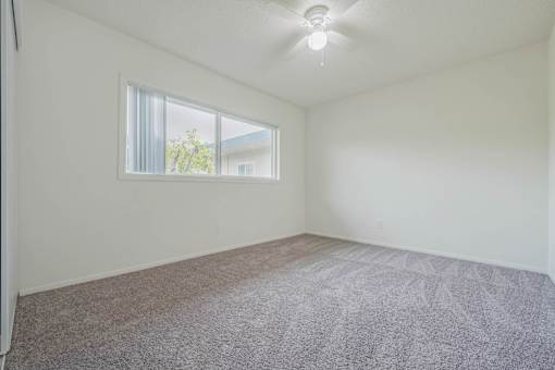 A room with a carpeted floor and a window.