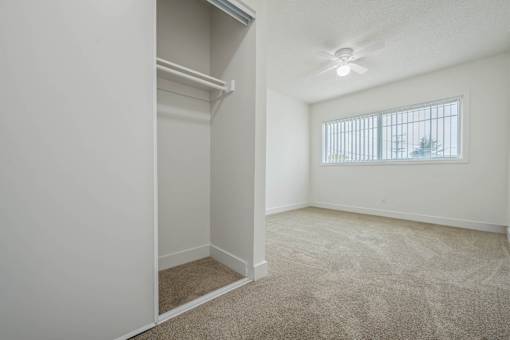 A room with a window and a carpeted floor.