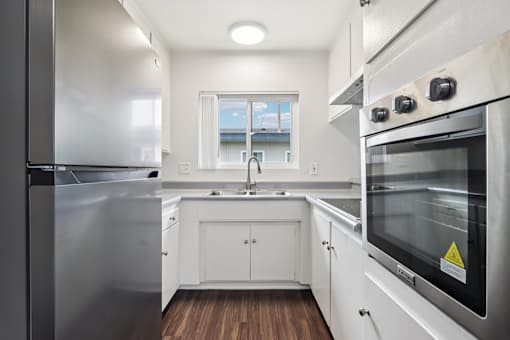 A modern kitchen with stainless steel appliances and white cabinetry.
