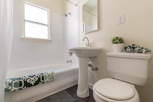 A white bathroom with a toilet, sink, and bathtub.