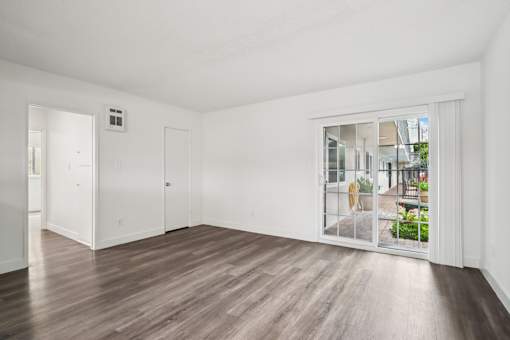 A room with a sliding glass door leading to a balcony.