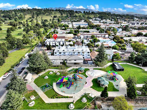 A playground with a slide and a red pin on a building.