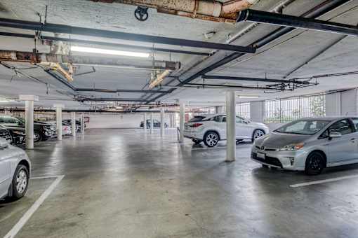 A parking garage with a white car in the foreground.