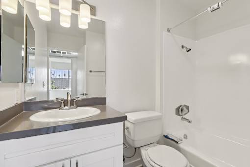 A white bathroom with a sink, toilet, and bathtub.