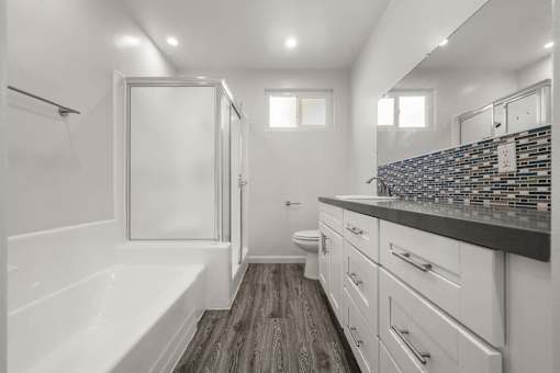 a white bathroom with a bath tub and a shower