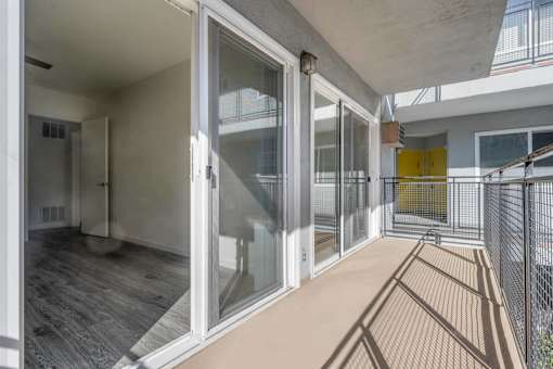 a sliding glass door opens to a balcony with a yellow door