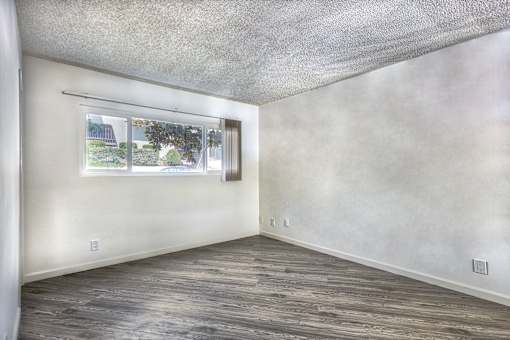 an empty room with white walls and a window