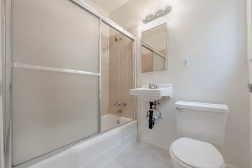 A white toilet sits next to a sink in a bathroom.