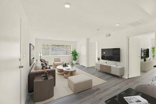 A modern living room with a large couch, a coffee table, and a television.