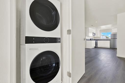 A modern laundry room with a washer and dryer stacked on top of each other.