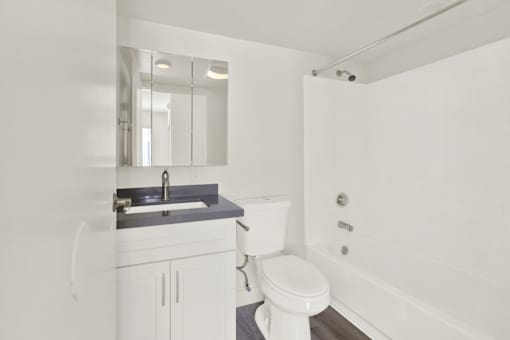 A white bathroom with a sink, toilet, and bathtub.