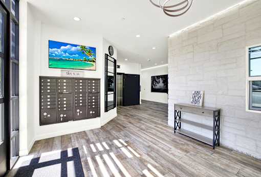 A modern interior with a wooden floor and a large painting of a beach scene on the wall.