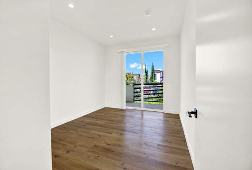 A room with a wooden floor and a sliding glass door.