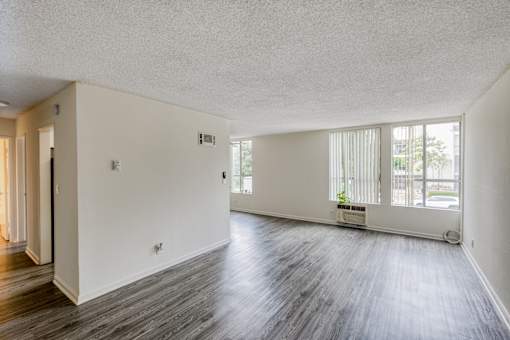 A large empty room with wooden floors and white walls.