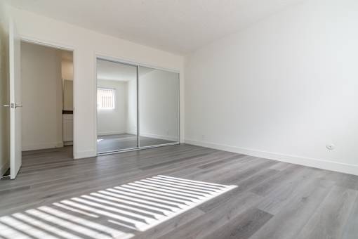 A room with a sliding glass door and a wooden floor.