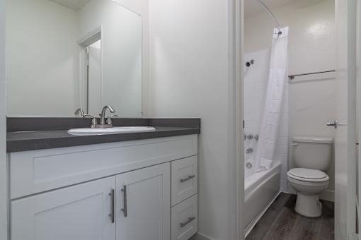 A white bathroom with a sink, toilet, and bathtub.