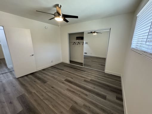 a living room with wood flooring and a ceiling fan