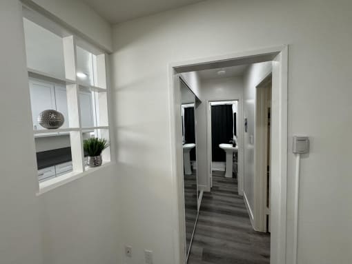 a small hallway with a mirror and a door to a bathroom
